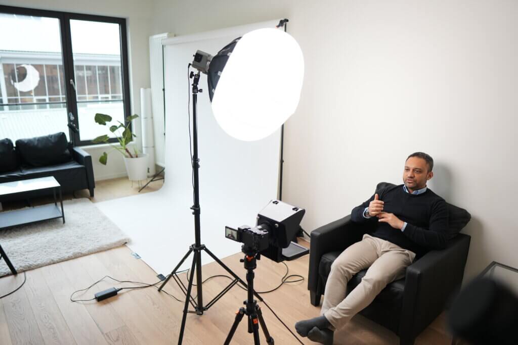 Client enregistrant une vidéo professionnelle dans le studio Brandamax, assis face au téléprompteur